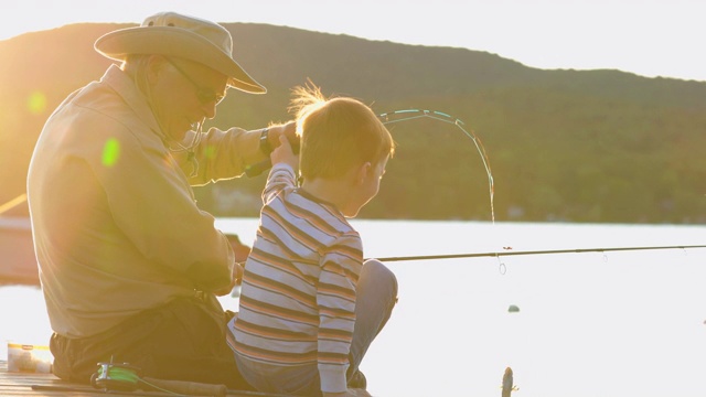 爷爷和孙子在夏天的日落钓鱼视频下载