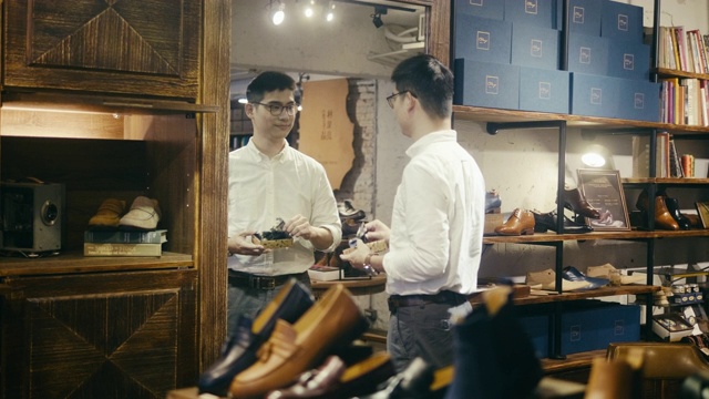 亚洲男性顾客在男装鞋店试穿领结视频素材