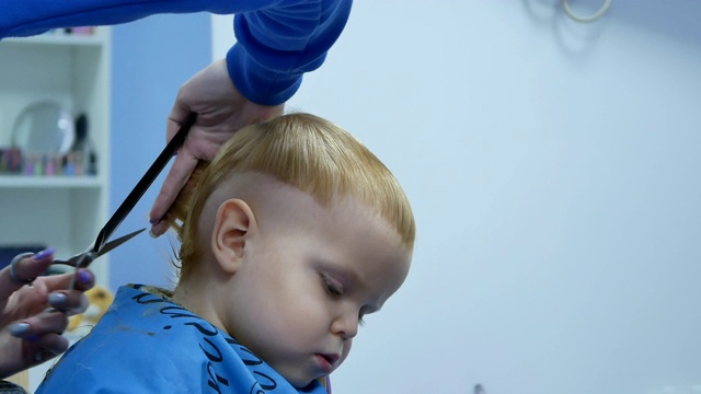 理发师从2岁的可爱男孩的后脑勺剪头发视频下载