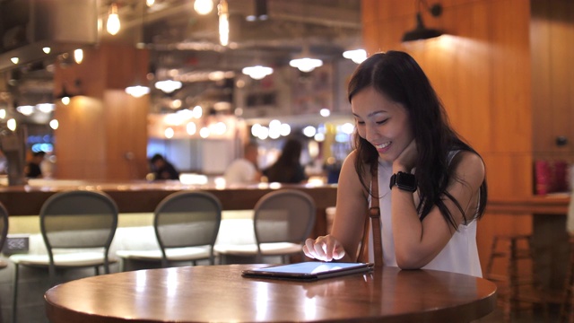 一名女子在咖啡馆里使用数字平板触屏电脑视频素材