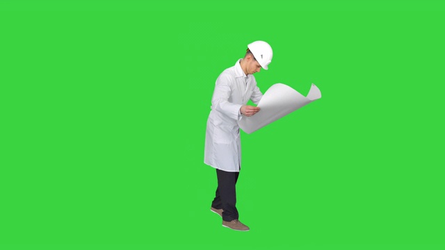 工程师与一个良好的心情在绿色屏幕上的蓝图跳舞，色度键视频素材