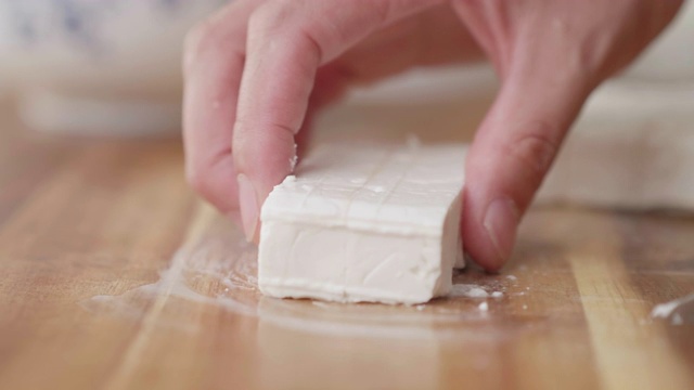 用手将羊乳酪切成小方块，放在砧板上视频下载