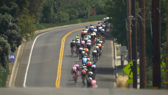 一群在公路自行车比赛中爬山的男子。——慢动作视频下载