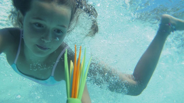 小女孩在游泳池的水下游泳视频素材