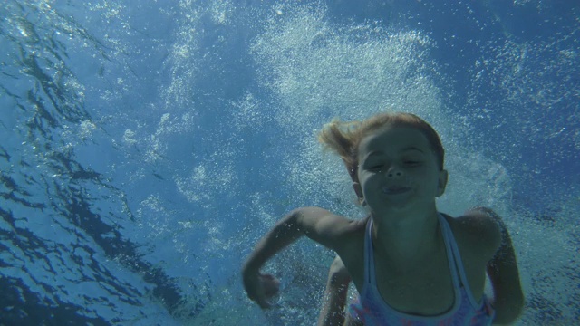 一个年轻女孩在游泳池里玩炮弹视频素材