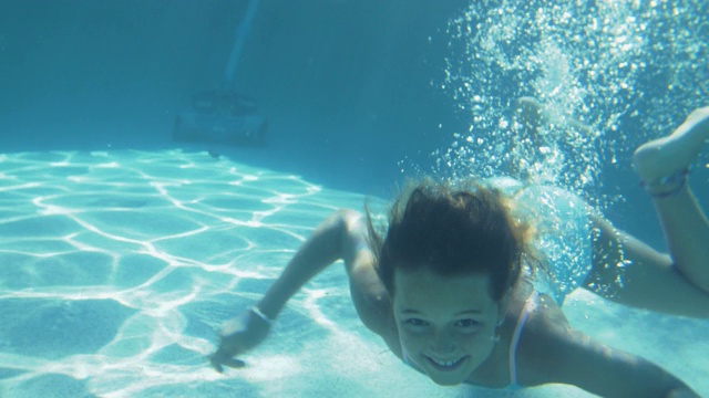 Slo Mo快乐的女孩在游泳池水下游泳视频素材