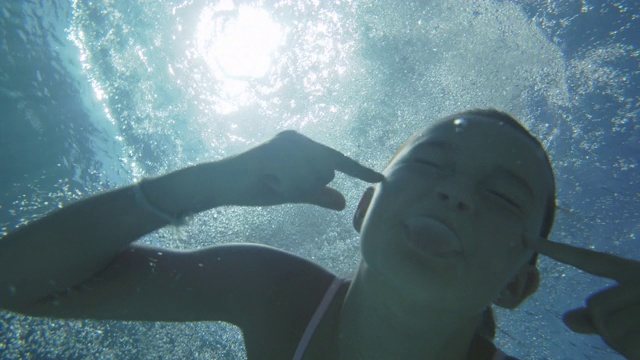 一个女孩跳进游泳池的镜头视频素材