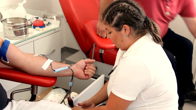 护士取血样进行分析。好事。为身体献血的好处。接受输血者的手。献血者在医疗诊所献血的特写视频下载