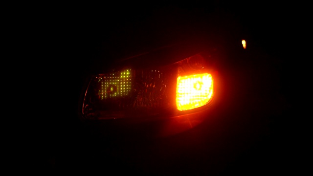 特写闪烁的黄色尾灯在晚上的汽车。缓慢的运动。视频素材