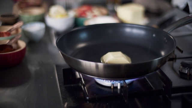 厨师在专业厨房用平底锅融化黄油视频下载