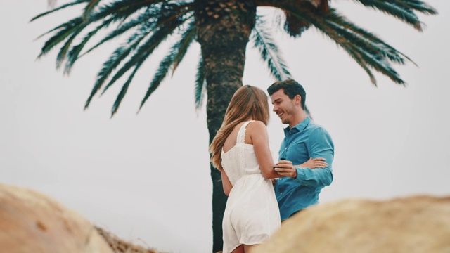 男人戴着戒指，在海滩上拥抱女朋友视频素材