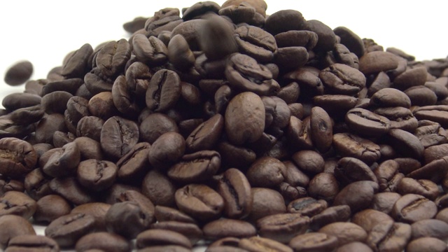 4k烤咖啡豆下落和旋转在白色背景视频素材