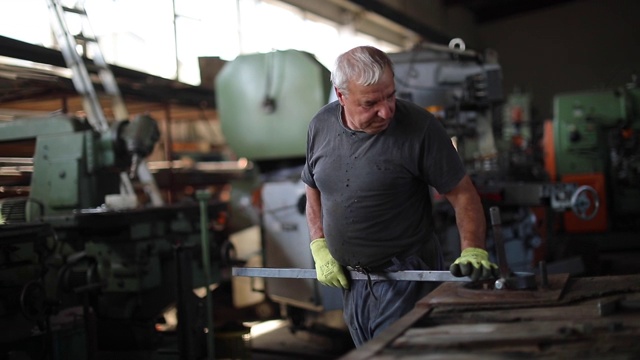 在工厂使用锤子折弯金属的高级人员视频素材