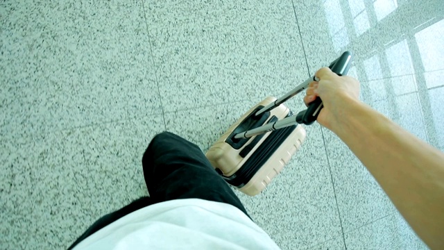 一名男子拿着行李在机场行走视频素材