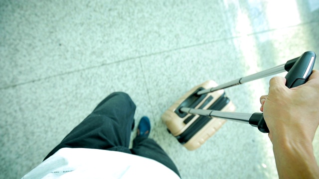 一名男子拿着行李在机场行走视频素材