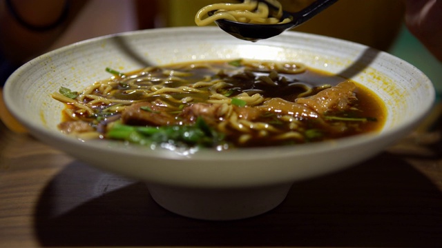 4K，亚洲女人用棍子吃牛肉面，中餐馆视频下载