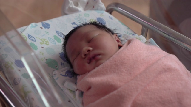 一个可爱的新生婴儿睡在病人康复室里视频素材