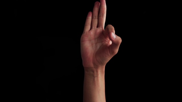 白人白人的手的特写镜头孤立的黑人出现，并显示f字母手语(美国手语)。视频下载
