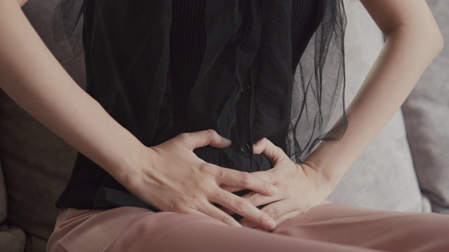 亚洲妇女有盆腔疼痛胃痛，而躺在沙发上在家视频下载