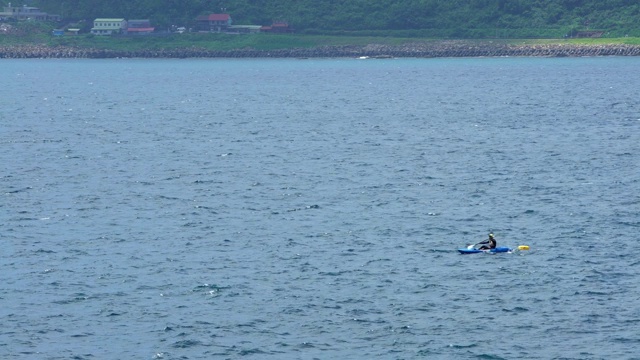 4K，男子在平静的海水上划着支腿独木舟。自然的冒险。视频素材
