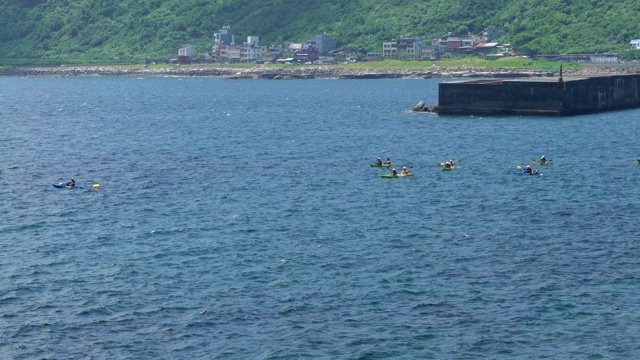 一群人在台湾平静的海水上划着支腿独木舟。视频素材