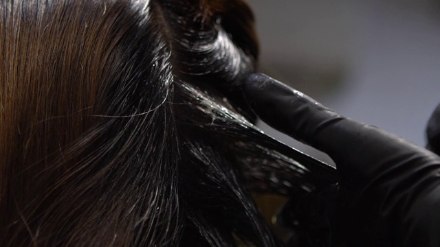 慢动作发型师使用染发剂提亮头发色调视频素材