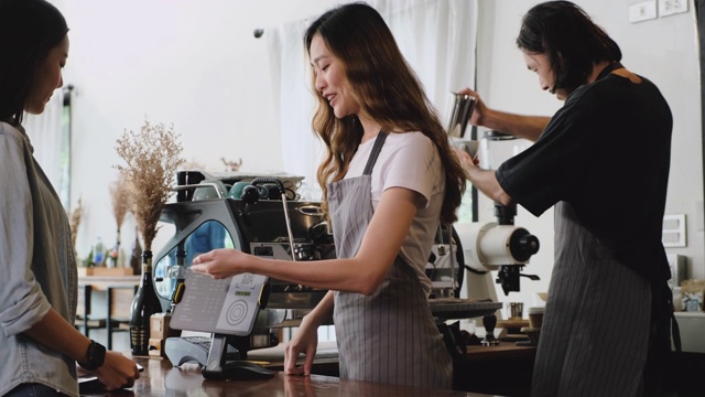 亚洲顾客通过平板电脑点咖啡，在咖啡厅柜台柜台用平板电脑进行非接触式手机支付。小型企业开始。客户服务理念视频素材