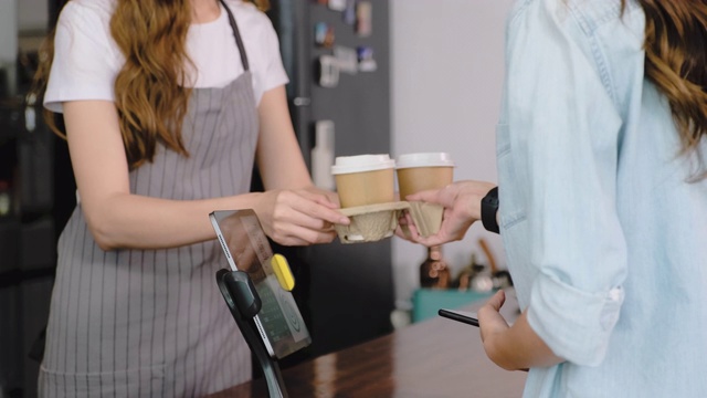 慢镜头亚洲顾客用平板电脑点咖啡，在咖啡厅柜台柜台用平板电脑非接触式支付。小型企业开始。客户服务理念视频素材