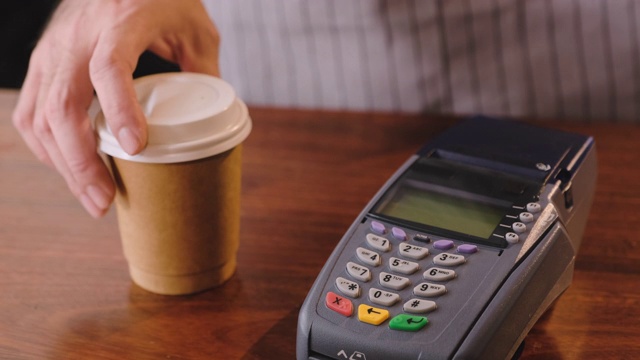 慢动作近距离使用手机钱包应用支付信用卡机上的非接触式在咖啡馆柜台酒吧。无线支付NFC生活方式视频下载