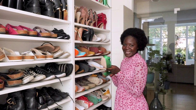 一个年轻女人在她的鞋子收藏品前的肖像视频下载