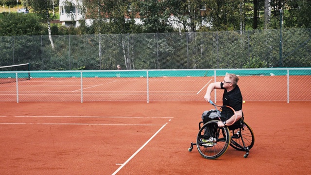 两个成年男子在户外轮椅网球上打双打视频素材
