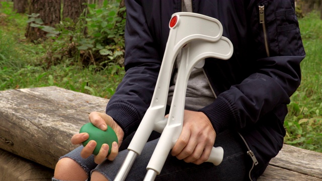 拄着拐杖的受伤女性挤压压力球。焦虑的概念视频素材