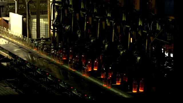 制造可乐瓶玻璃的工业工厂。在传送带上移动的透明空瓶。技术线生产视频下载
