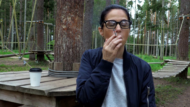 女性在公园低绳场附近吸烟视频素材