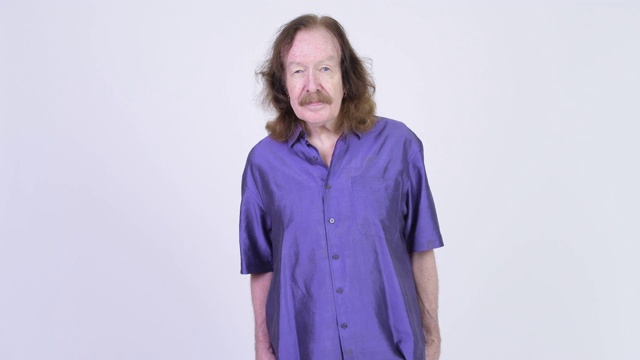 一个留着胡子，穿着丝质紫色衬衫的老人视频素材