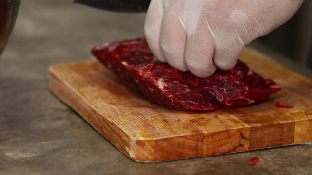 厨师手在木板上切生牛排视频素材