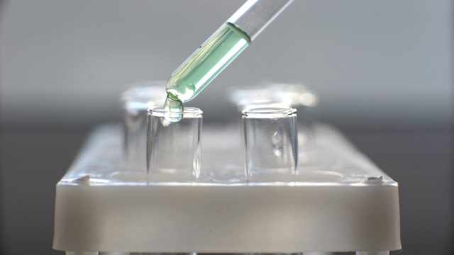 在实验室里，一位科学家用移液管分析一种有色液体视频素材