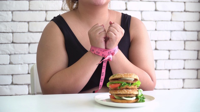 泰国体型庞大的女性试图通过卷尺来抑制吃汉堡包等不健康的食物视频下载