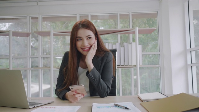 肖像美丽的年轻亚洲女商人和她的微笑在办公室。视频素材