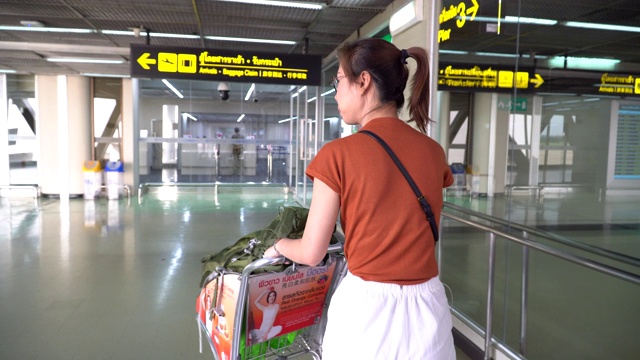 带着行李走过机场候机楼的女性游客视频素材