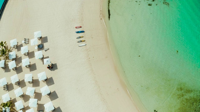 白色沙滩上的沙滩伞和躺椅视频素材
