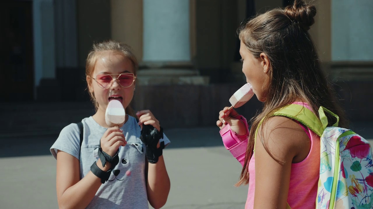 两个青少年在城市广场上吃冰淇淋视频下载