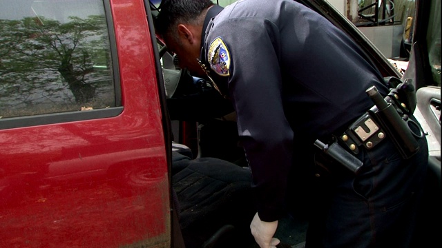警察使用电子仪器检查犯罪车辆的内部。视频素材