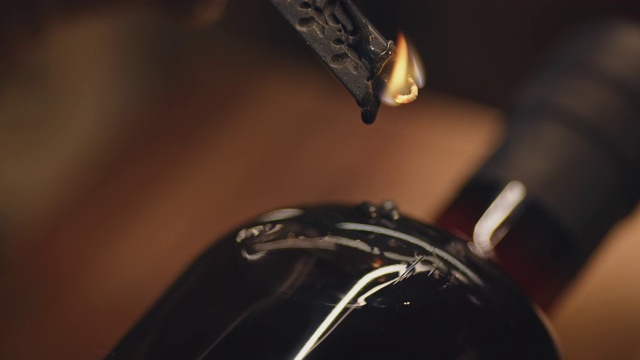 燃烧的黑色蜡烛落在瓶子上的特写视频素材