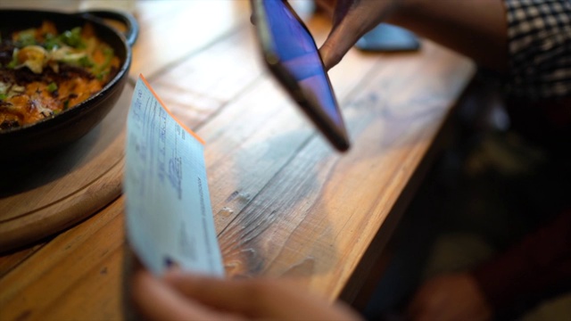 一名男子在餐厅用电话存支票视频素材
