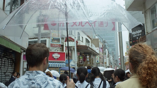一对白人夫妇在雨天穿过东京视频素材