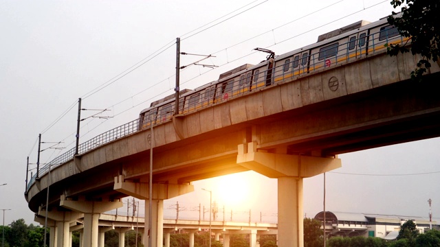 日落时分，德里地铁从大桥上驶过视频下载