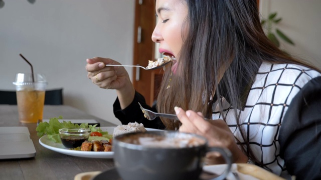 亚洲女商人在餐馆吃泰国菜的慢镜头，健康和城市生活的概念，东南亚的概念，典型的亚洲食物视频下载