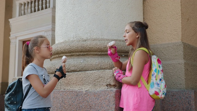 两个女性朋友在城市里吃冰淇淋聊天视频素材