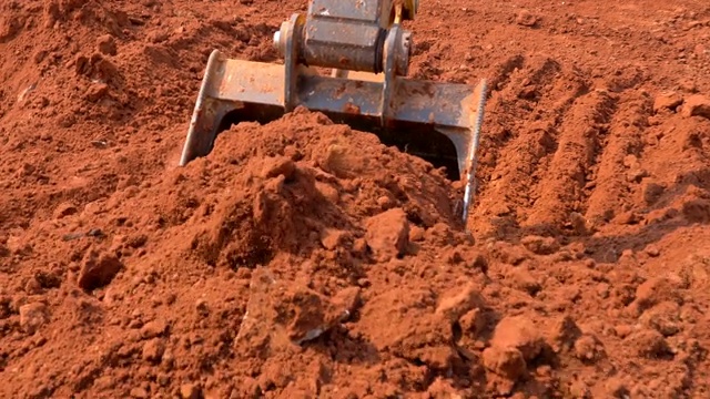现场挖掘机斗在阳光下挖土施工视频下载